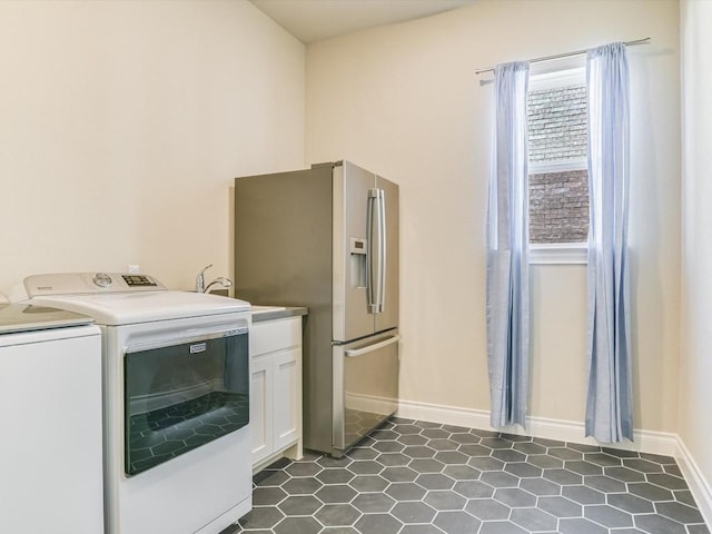 laundry room with cabinet space, a sink, washer and clothes dryer, and baseboards