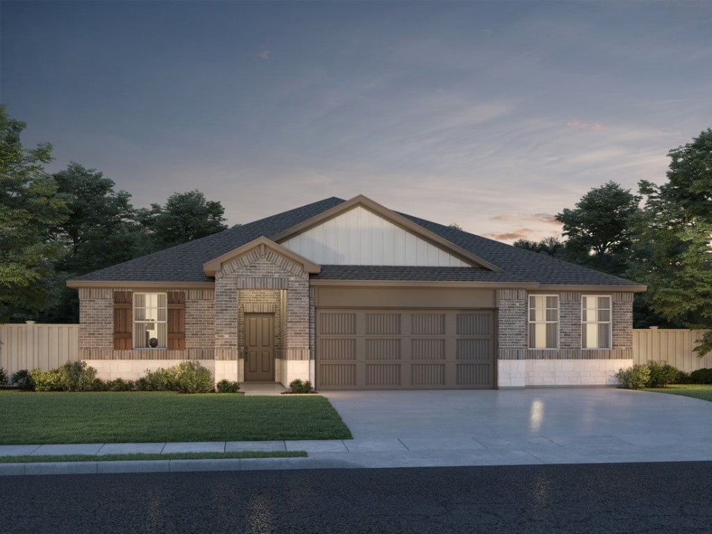 view of front facade featuring brick siding, a front yard, fence, a garage, and driveway