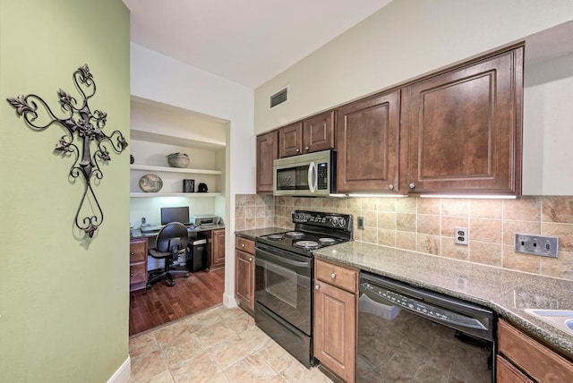 kitchen with dark stone countertops, visible vents, backsplash, and black appliances