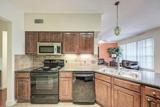 kitchen featuring visible vents, a sink, stone counters, black appliances, and backsplash