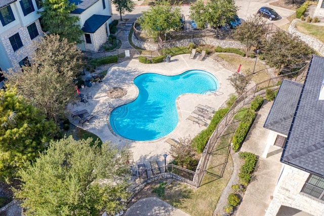 community pool with fence and a patio