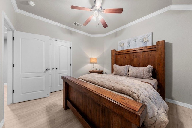 bedroom with light wood-type flooring, visible vents, a closet, and ornamental molding