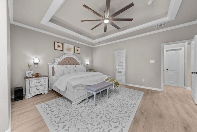 bedroom featuring ornamental molding, a raised ceiling, visible vents, and light wood-style flooring