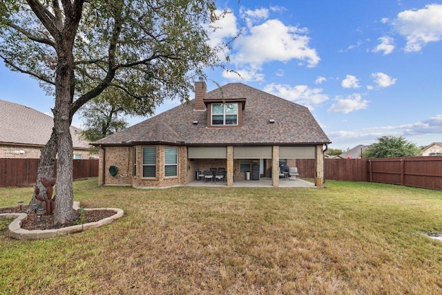 rear view of property featuring a patio, a fenced backyard, brick siding, a yard, and a chimney