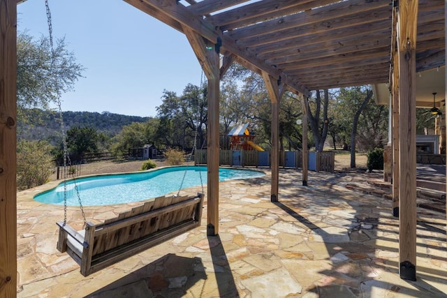 view of pool featuring a patio area, a playground, and a fenced backyard