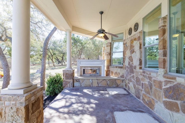 view of patio / terrace with a glass covered fireplace and a ceiling fan