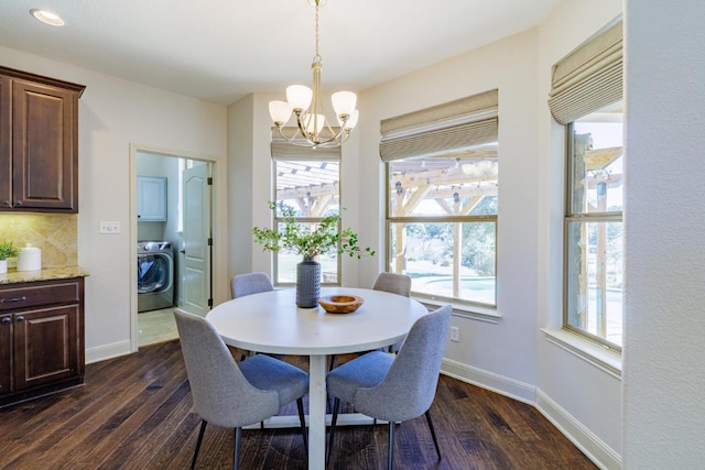 dining space with an inviting chandelier, baseboards, washer / clothes dryer, and dark wood finished floors