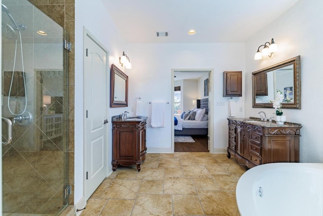 ensuite bathroom featuring a stall shower, two vanities, and a sink