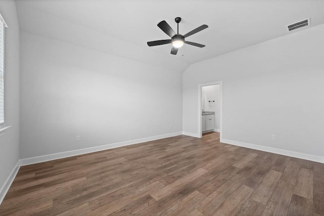 unfurnished room with a ceiling fan, wood finished floors, visible vents, and baseboards