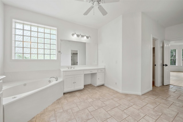 bathroom featuring baseboards, vanity, a bath, and a ceiling fan