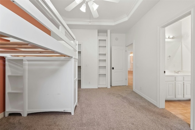 walk in closet with a sink, carpet, a raised ceiling, and a ceiling fan