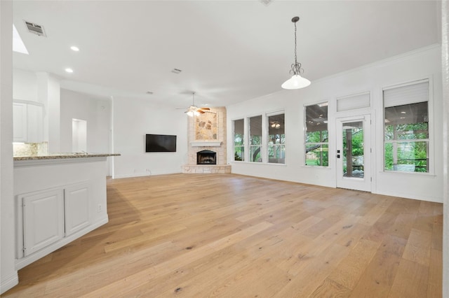 unfurnished living room with a fireplace, recessed lighting, visible vents, a ceiling fan, and light wood-style floors