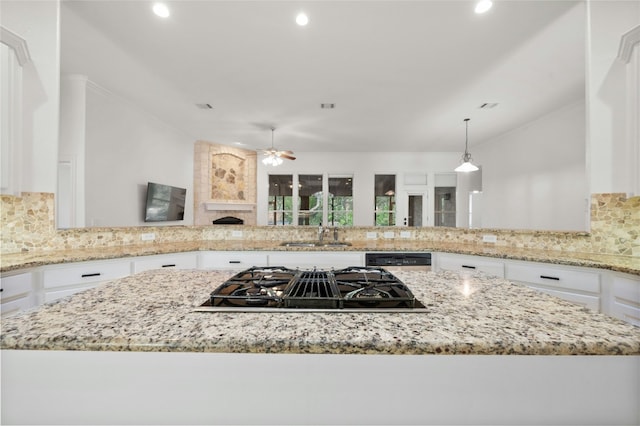 kitchen with light stone counters, stovetop with downdraft, white cabinets, and decorative backsplash