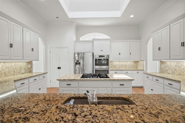 kitchen featuring appliances with stainless steel finishes, light stone counters, and white cabinets