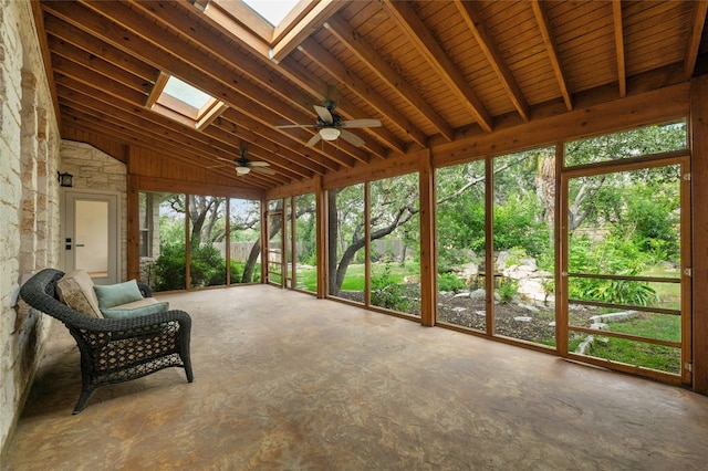 unfurnished sunroom featuring vaulted ceiling with skylight and ceiling fan