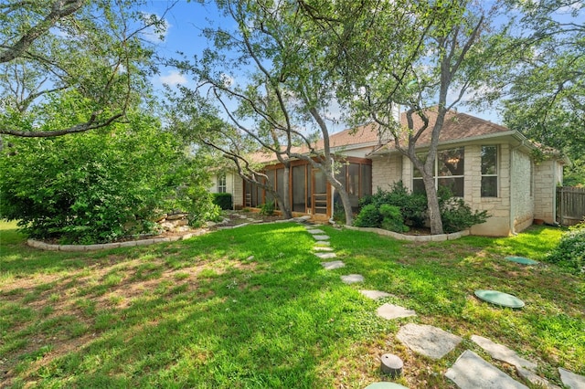 view of yard featuring a sunroom and fence