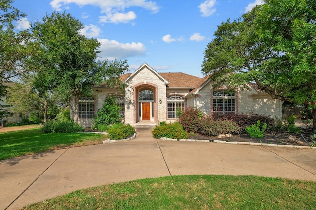 view of front of house with stone siding and a front yard