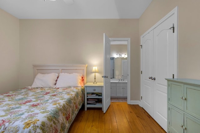 bedroom with ensuite bathroom, ceiling fan, a closet, and light wood-type flooring