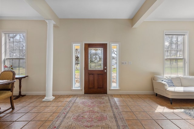 entrance foyer with decorative columns, baseboards, crown molding, and light tile patterned flooring