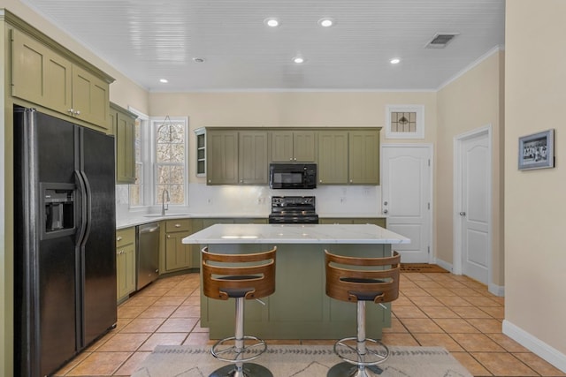 kitchen featuring green cabinetry, a sink, black appliances, and light tile patterned flooring