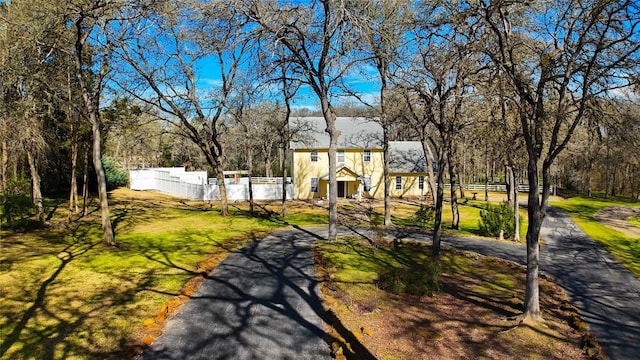 view of home's community featuring fence and a yard