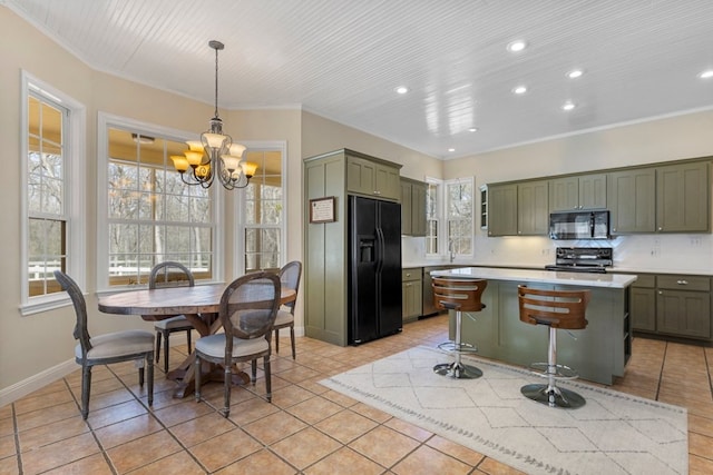 kitchen featuring a kitchen breakfast bar, a center island, light countertops, black appliances, and light tile patterned flooring