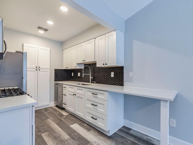 kitchen with visible vents, decorative backsplash, dark wood-style floors, appliances with stainless steel finishes, and a sink