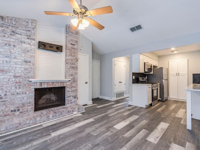 3839 Dry Creek Dr Unit 216, Austin, TX 78731 - unfurnished living room featuring a ceiling fan, visible vents, a fireplace, lofted ceiling, and dark wood-type flooring