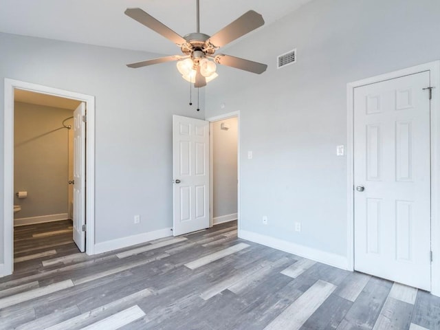 unfurnished bedroom featuring a ceiling fan, wood finished floors, visible vents, and baseboards