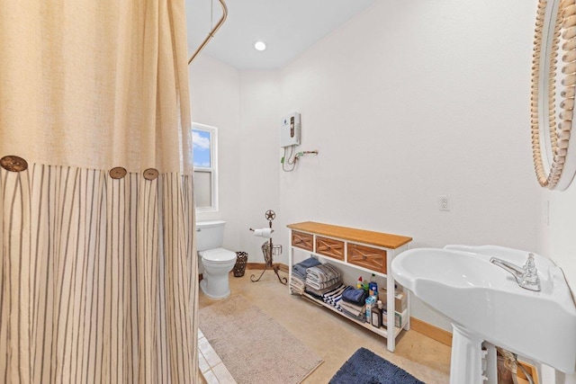 bathroom with toilet, baseboards, and a sink