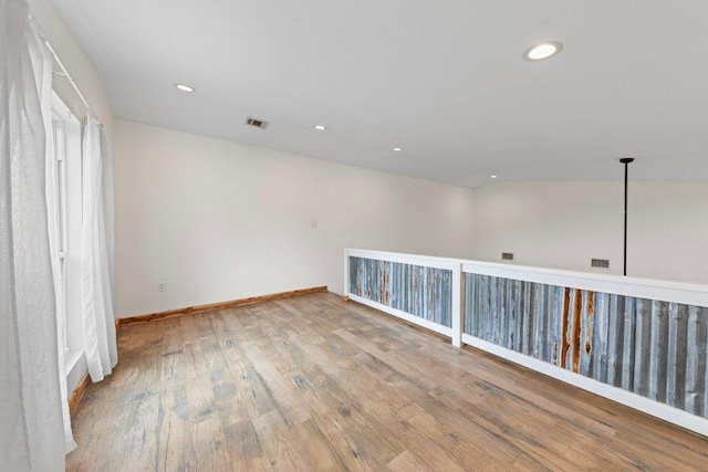 spare room featuring baseboards, wood finished floors, visible vents, and recessed lighting