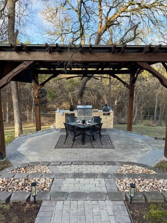 view of patio featuring outdoor dining space, grilling area, and an outdoor kitchen