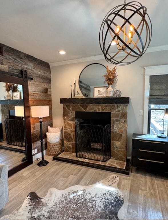 sitting room featuring a fireplace, recessed lighting, ornamental molding, wooden walls, and wood finished floors