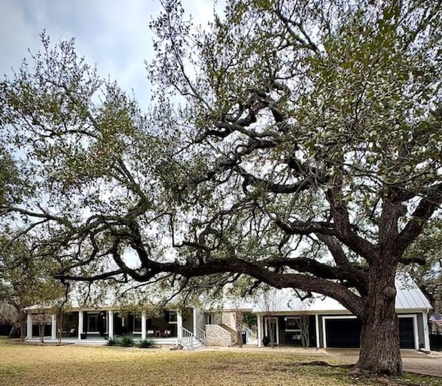 view of front facade featuring a garage, a standing seam roof, metal roof, and a front yard