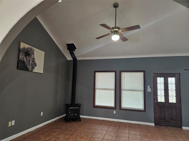 unfurnished living room featuring baseboards, lofted ceiling, ceiling fan, tile patterned floors, and a wood stove