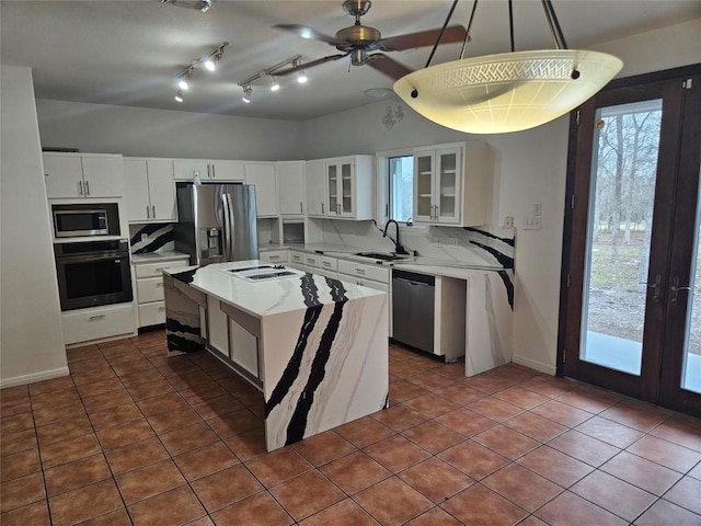 kitchen featuring backsplash, stainless steel appliances, a sink, and french doors