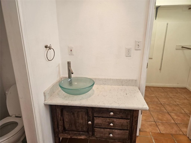 bathroom featuring toilet, tile patterned flooring, and vanity