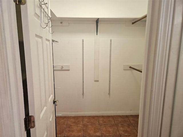 walk in closet featuring dark tile patterned flooring