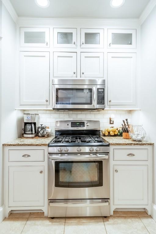 kitchen featuring appliances with stainless steel finishes, white cabinets, and decorative backsplash