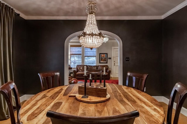 dining area with arched walkways, baseboards, a chandelier, and crown molding