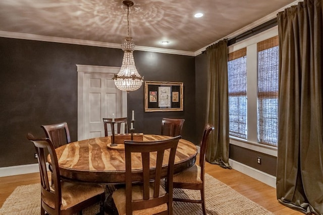 dining area with light wood finished floors, a notable chandelier, baseboards, and crown molding