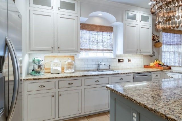 kitchen with white cabinets, appliances with stainless steel finishes, decorative backsplash, and a sink