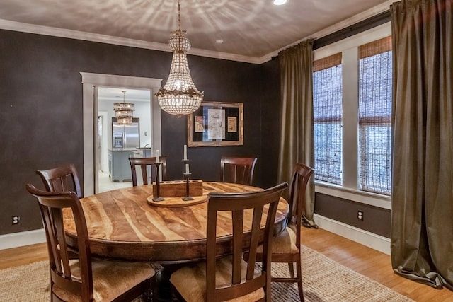 dining room with baseboards, wood finished floors, and crown molding