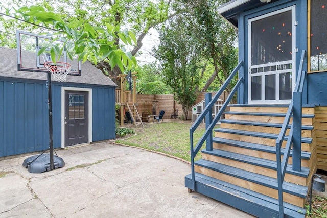 view of patio with stairs, fence, and an outdoor structure