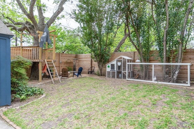 view of yard featuring an outdoor fire pit, a fenced backyard, and exterior structure