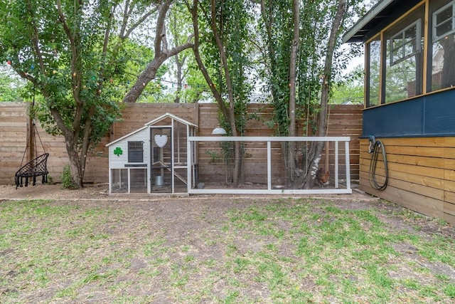 view of yard featuring an outdoor structure, a fenced backyard, and exterior structure