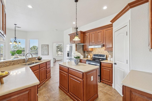 kitchen featuring under cabinet range hood, a sink, a center island, appliances with stainless steel finishes, and brown cabinets