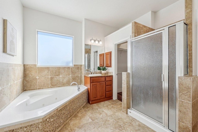 bathroom featuring a stall shower, tile patterned floors, a whirlpool tub, a walk in closet, and vanity