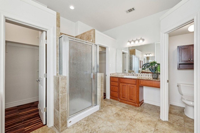 bathroom with a stall shower, baseboards, visible vents, toilet, and vanity