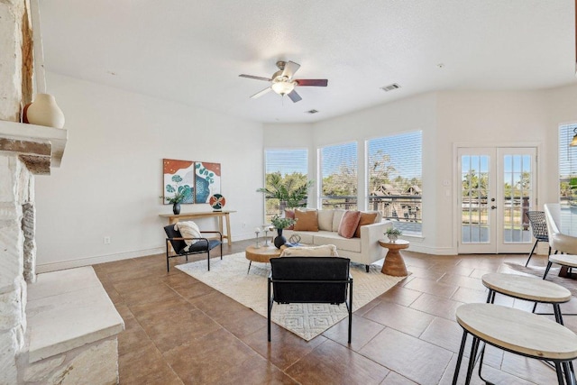 living area featuring french doors, visible vents, a ceiling fan, tile patterned flooring, and baseboards